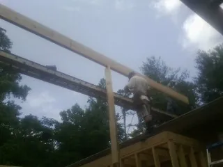 Carpenter setting a ridge beam over a new addition frame — Ice Dam Removal by Roofing Brothers in Villa Rica