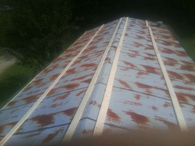 Rusted metal roof panels with new wood purlins before replacement — Storm Damage Roof Repair in Villa Rica by Roofing Brothers