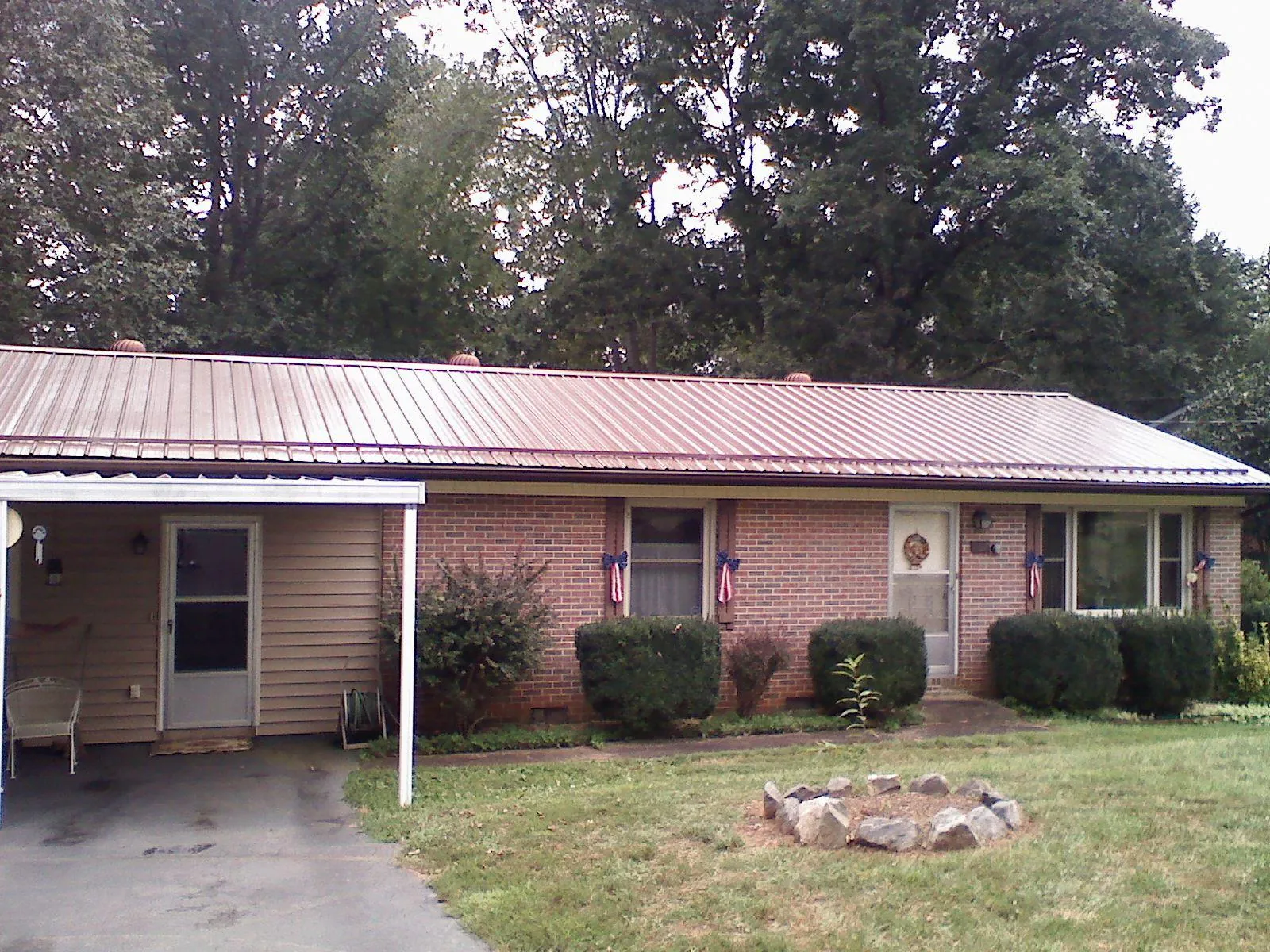 Bronze metal roof and carport on a brick ranch home — Roof Repair work by our crew in Villa Rica