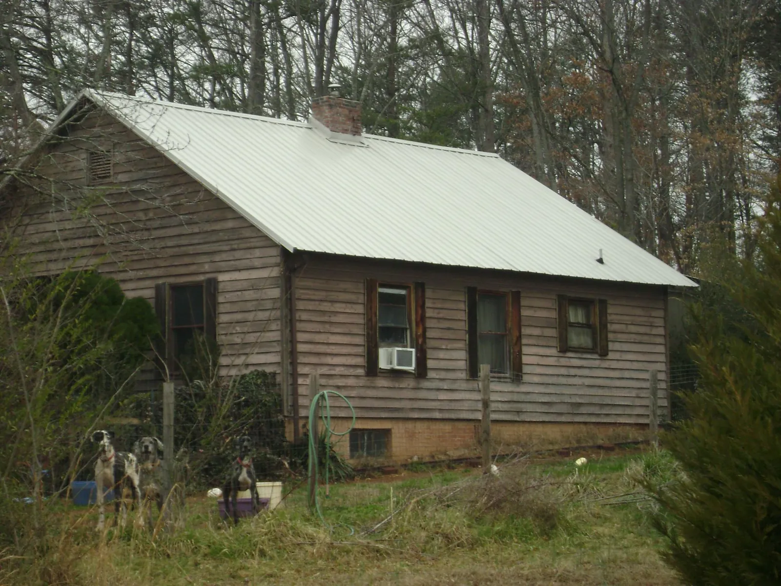 White metal roof on an old wood sided farmhouse, from a Metal Roof Installation job in Villa Rica